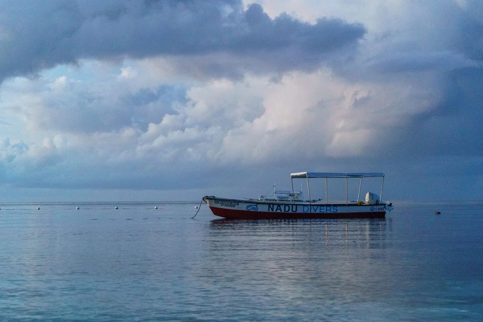 A dive boat moored on still water